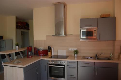 eine Küche mit einem Herd und einer Mikrowelle in der Unterkunft Blaue Perle Wohnung Nr 16-3 in Schönberger Strand