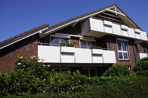 a red brick house with white balconies on it at Kleine Galerie in Schönberger Strand