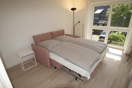 ein großes Bett in einem Zimmer mit Fenster in der Unterkunft Kleine Galerie in Schönberger Strand