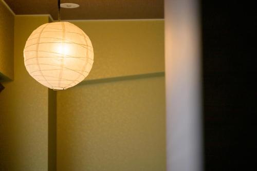 a paper lantern hanging from a ceiling in a room at Hiroshima Wabisabi hotel - 市内中心部のリーズナブルホテル - 電停近く移動に便利 - Low price and super convenient to get around, despite being in the center of city - supported by COCOSTAY in Hiroshima