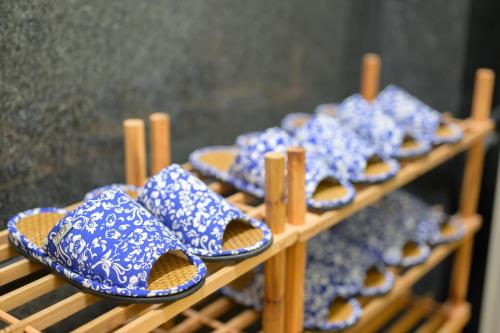 a row of blue and white shoes on a shelf at Hiroshima Wabisabi hotel - 市内中心部のリーズナブルホテル - 電停近く移動に便利 - Low price and super convenient to get around, despite being in the center of city - supported by COCOSTAY in Hiroshima