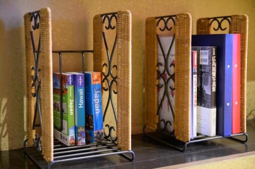 a shelf with a bunch of books on it at Hiroshima Wabisabi hotel - 市内中心部のリーズナブルホテル - 電停近く移動に便利 - Low price and super convenient to get around, despite being in the center of city - supported by COCOSTAY in Hiroshima