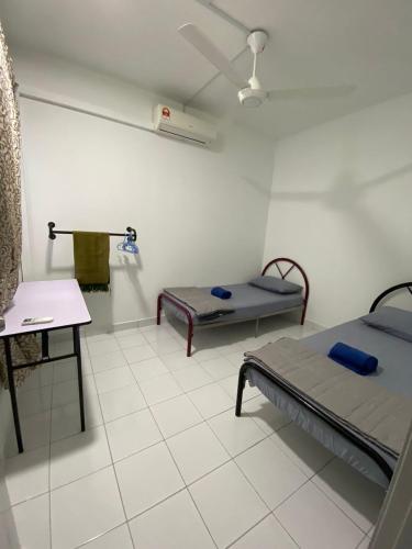 a hospital room with two beds and a table at YAYA HOMESTAY CYBERJAYA & PUTRAJAYA in Cyberjaya