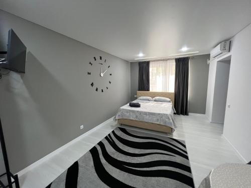 a bedroom with a bed and a clock on the wall at Apartamets rent Edinet-аренда квартир единец in Edineţ