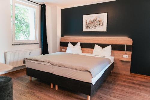 ein Schlafzimmer mit einem großen Bett und einer schwarzen Wand in der Unterkunft Palais in Erfurt