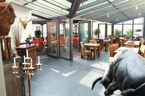 ein Restaurant mit einer Kuhstatue in der Mitte des Zimmers in der Unterkunft Palais in Erfurt