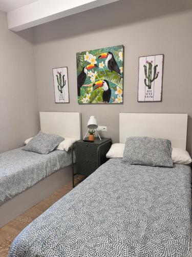 a bedroom with two beds and paintings on the wall at Habitación Doble - Apartamento in Estella