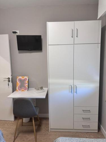 Habitación Doble - Apartamento في إستيلا: خزانة بيضاء بجوار مكتب مع جهاز كمبيوتر