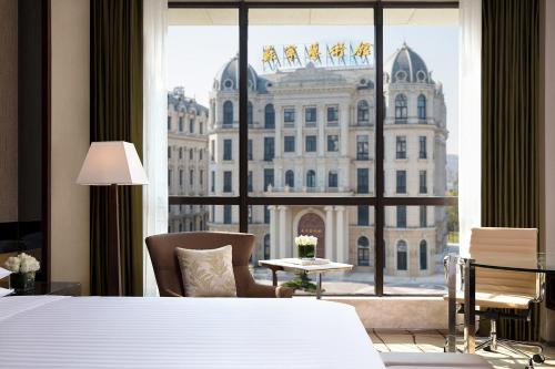 een hotelkamer met een bed en een groot raam bij Courtyard by Marriott Shanghai Changfeng Park in Shanghai