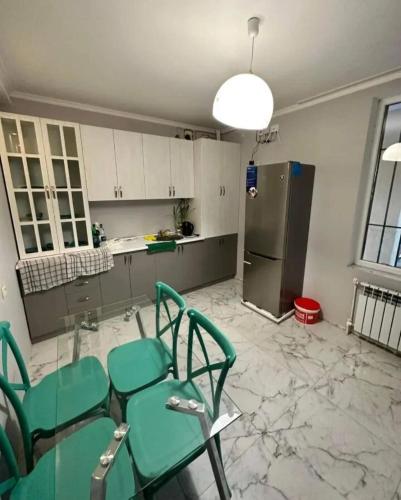 a kitchen with green chairs and a table and a refrigerator at Kirovakan Vacation House in Vanadzor