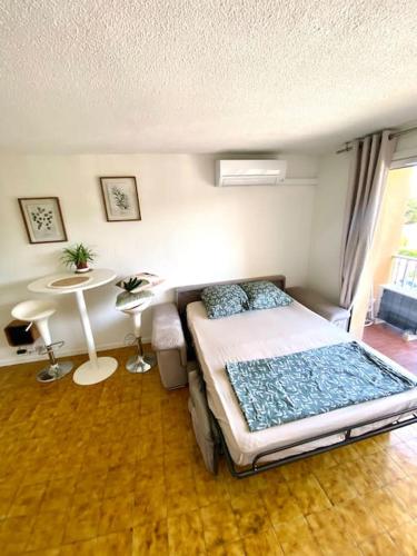 sypialnia z łóżkiem i stołem w obiekcie Studio apartment Fréjus w Fréjus