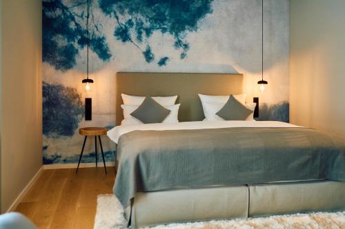 Hofgut Wißberg - Das Weinberghotel في Sankt Johann: غرفة نوم بسرير كبير عليها لوحة على الحائط