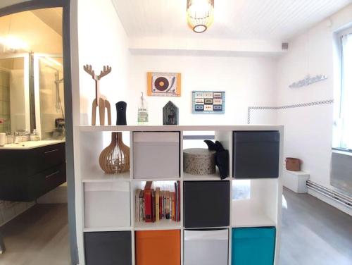 - une salle de bains pourvue d'étagères colorées dans l'établissement La Parenthèse Géromoise, à deux pas de la navette pour le ski, à Gérardmer