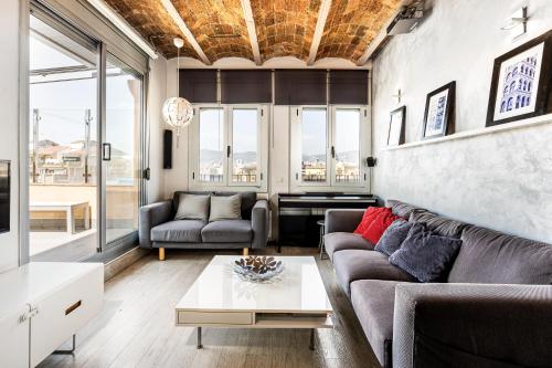 a living room with a couch and a table at Stunning 2-bedroom Apartment With Two Terraces in Barcelona