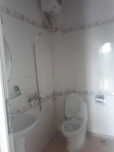 a white bathroom with a toilet and a sink at Nhà nghỉ 99 