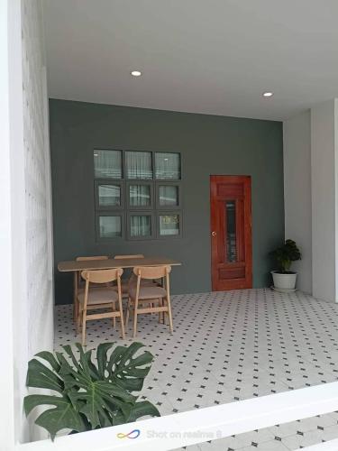 a room with a table and two chairs and a door at บ้านสุขใจ อัมพวา in Samut Songkhram
