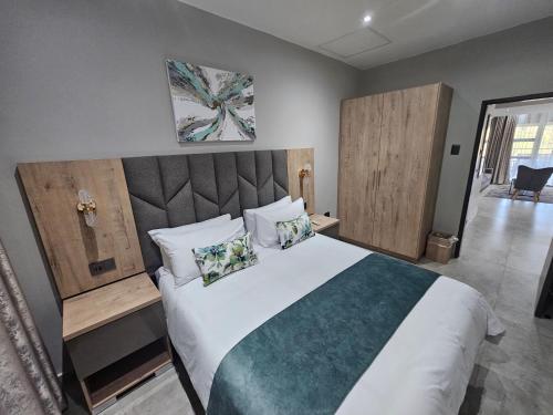 een slaapkamer met een groot wit bed met kussens bij Casa De Luxe in Ballito