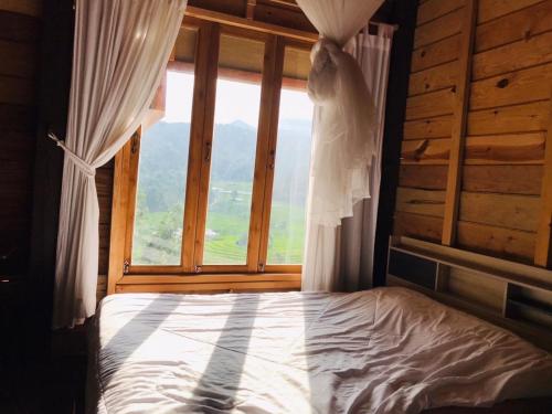 a bed in a room with a window at Motho Homestay โมโทโฮมสเตย์ in Chom Thong