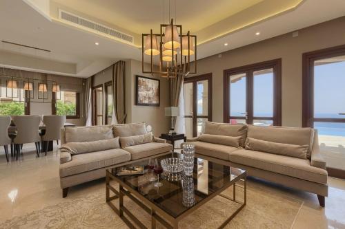 a living room with two couches and a table at Aphrodite Hills Rentals - Mythos Collection Villas in Kouklia
