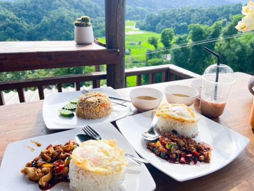 two plates of food on a table with rice at Motho Homestay โมโทโฮมสเตย์ in Chom Thong
