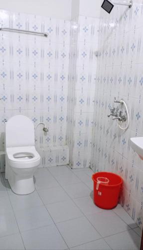 a bathroom with a toilet and a sink and a bucket at Noor Plaza in Angamali