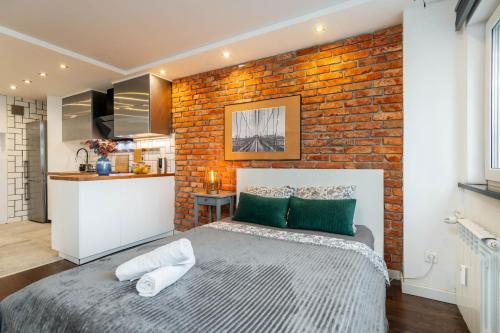 een slaapkamer met een bakstenen muur en een bed bij Chmielna 106B Centrum by VAYA STAYS in Warschau