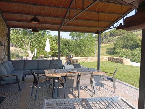 a patio with a couch and a table and chairs at Case Vacanza Villa Bentivoglio in Piazza Armerina