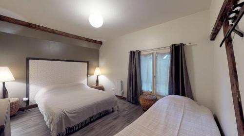 a bedroom with two beds and a window at Appartement Ecuries du Val de Mai, 10pers in Talmas