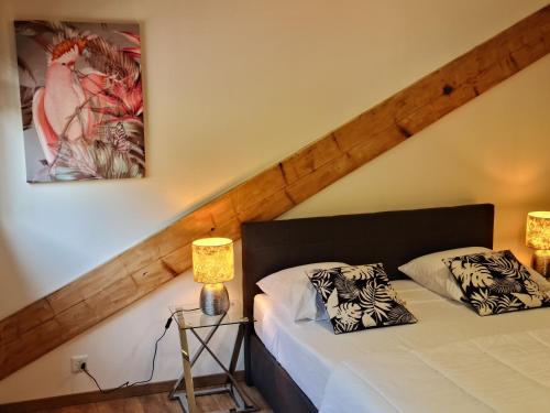 two beds in a room with two lamps and a painting at La Factory in Porrentruy