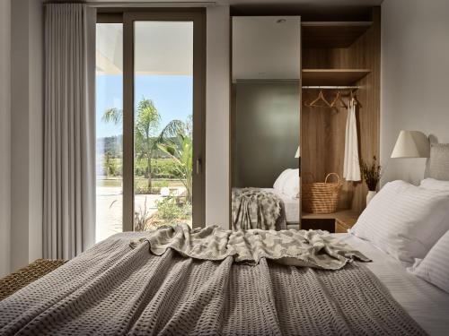 een slaapkamer met een bed en een raam met uitzicht bij Azera Suites in Alikanas
