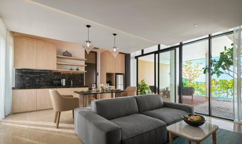 an open living room with a couch and a kitchen at PARKROYAL Langkawi Resort in Pantai Cenang