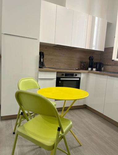 une table jaune et deux chaises dans une cuisine dans l'établissement Varavilla, Très jolie 2P proche Monaco, à Roquebrune-Cap-Martin