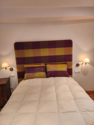 Dormitorio con cama grande y cabecero colorido en La casa sobre el rÍo, en Cuenca