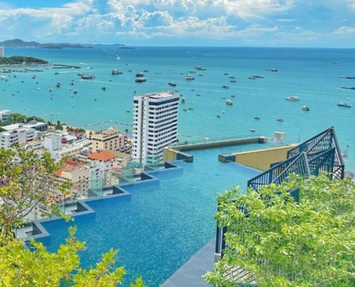 a view of a city and the ocean with boats at Edge Central PATTAYA Sky Residence with Infinity Pool & Free Netflix in Pattaya Central