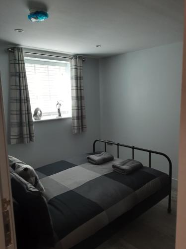 Bett in einem Zimmer mit einem Fenster und einem Bett sidx sidx sidx sidx in der Unterkunft 2 The Maltings Apartments in Shepton Mallet