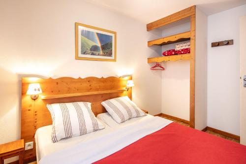 une chambre avec un lit avec une couverture rouge dans l'établissement Le Silène - Appt pour 6, à Chamrousse