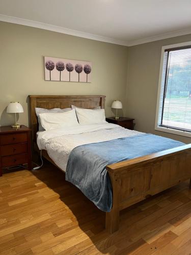 a bedroom with a large bed with two nightstands and two windows at Thie My Chree Retreat in Herne Hill