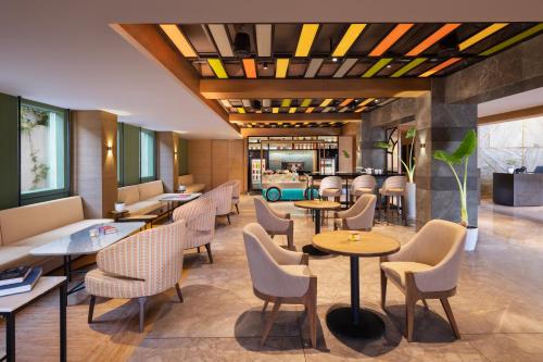 a restaurant with tables and chairs and a lobby at Hyatt Place Vijayawada in Vijayawāda
