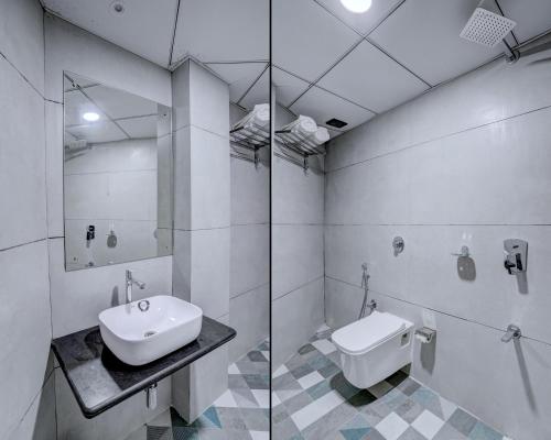 a white bathroom with a sink and a shower at Arts International in Mumbai