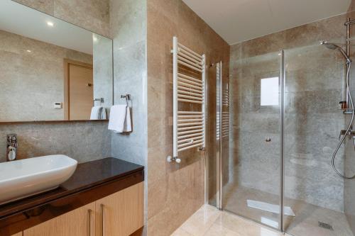 a bathroom with a glass shower and a sink at Aphrodite Hills Rentals - Mythos Collection Villas in Kouklia