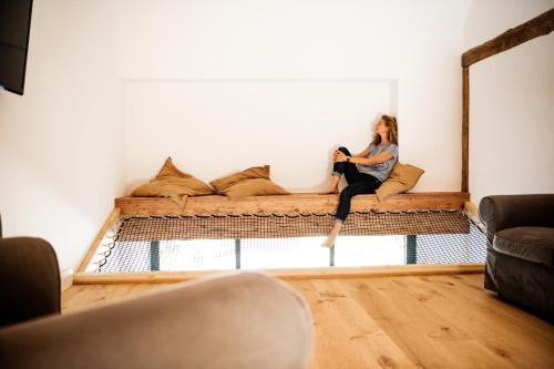 a woman sitting on a couch in a living room at Zauberhafte Ferienscheune im Hofgut Alte Ölmühle in Engen