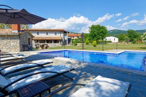 einen Pool mit Liegestühlen und einem Sonnenschirm in der Unterkunft Holiday Home Eda in Buzet