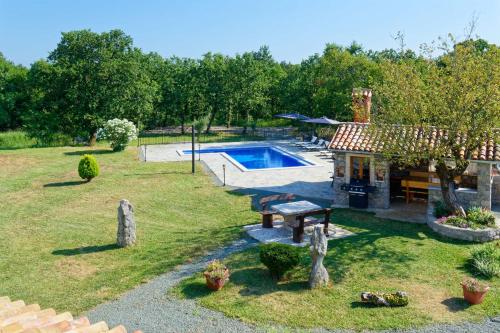un patio trasero con piscina y una casa en Holiday Home Eda, en Buzet