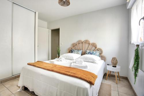 a bedroom with a large white bed with a large mirror at Expédition Malouine - Appt à 30m de la plage in Saint Malo