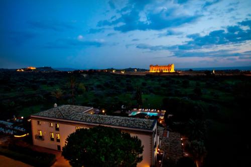 a view of a building in the distance at night at Villa Athena Resort in Agrigento