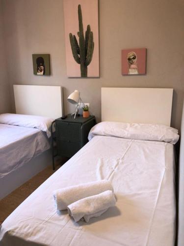 sypialnia z 2 łóżkami i ręcznikami w obiekcie Habitación Doble en el centro - Apartamento w mieście Estella