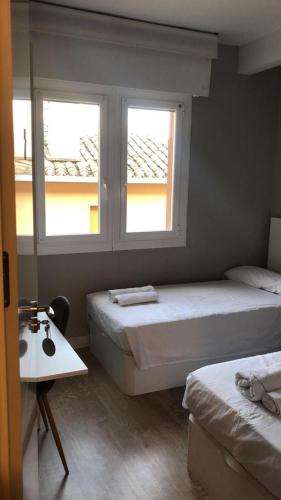 2 camas en una habitación con 2 ventanas en Habitación Doble en el centro - Apartamento en Estella