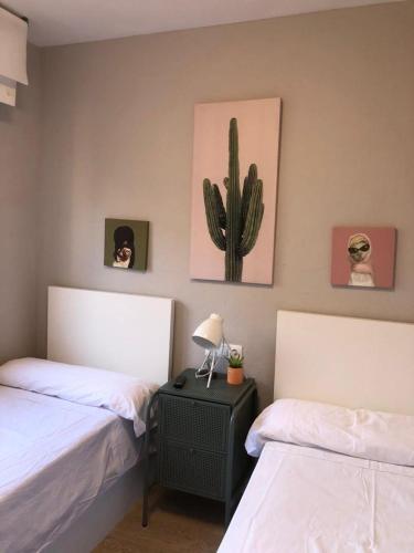 1 dormitorio con 2 camas y un cactus en la pared en Habitación Doble en el centro - Apartamento en Estella
