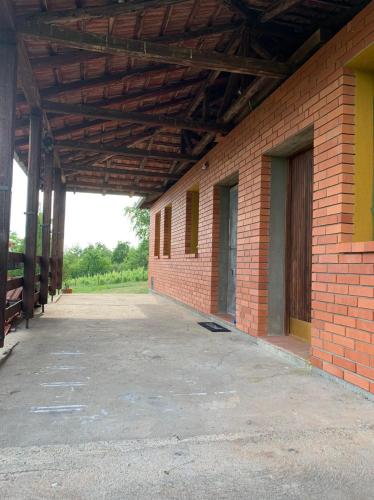 an empty building with a brick wall and an open garage at Cottage House Official in Niš