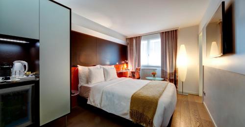 a hotel room with a bed and a television at Design Hotel f6 in Geneva